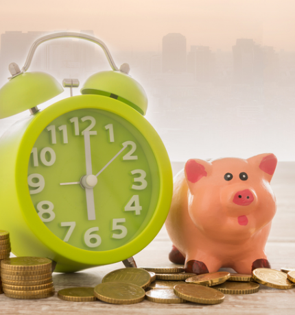 A piggy bank with coins for a short term loan next to a clock