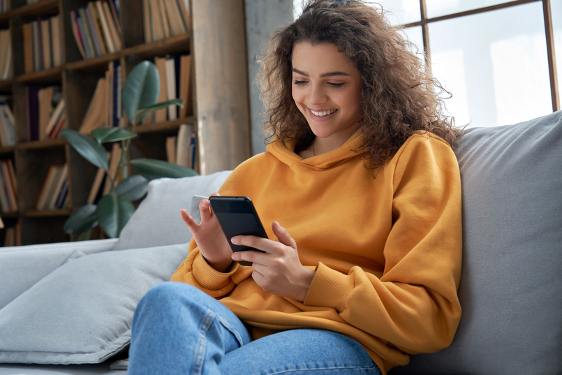 A woman studies her phone, recognizing the potential impact of an installment loan on her life, as she discovers the option to apply for an installment loan through Integra Credit.