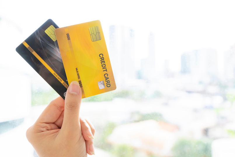 a woman holding both a charge card and a credit card