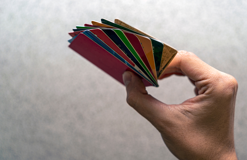 A man holding a stack of credit cards with multiple personal loans attached to them.