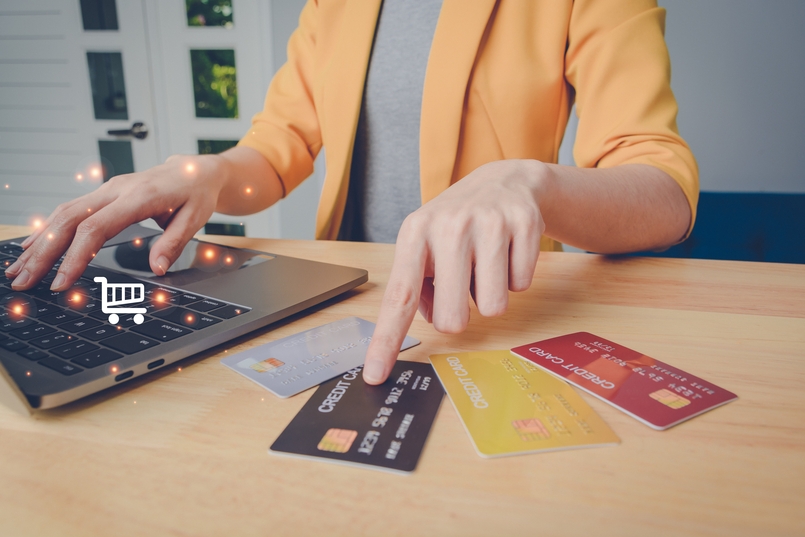 secured and unsecured credit cards laying on a table next to a laptop