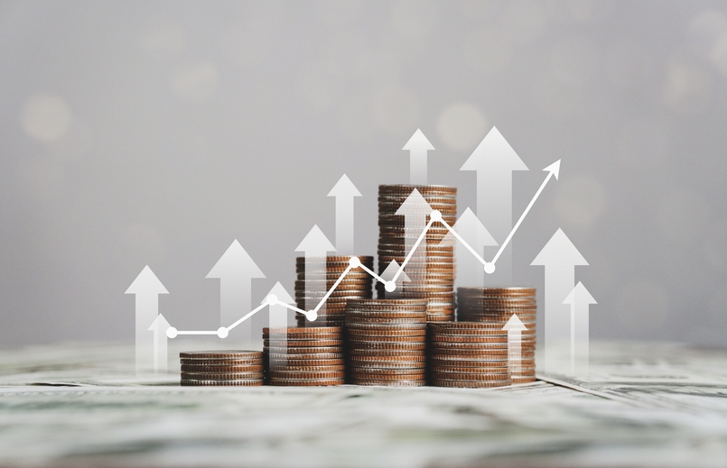 Silver coins stacked with an inflation chart, representing financial concepts and investment in the context of rising prices.