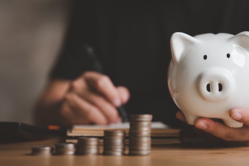 A man examines his monthly budget, attempting to distribute funds from his paycheck to paycheck lifestyle between his expenses and savings accounts.