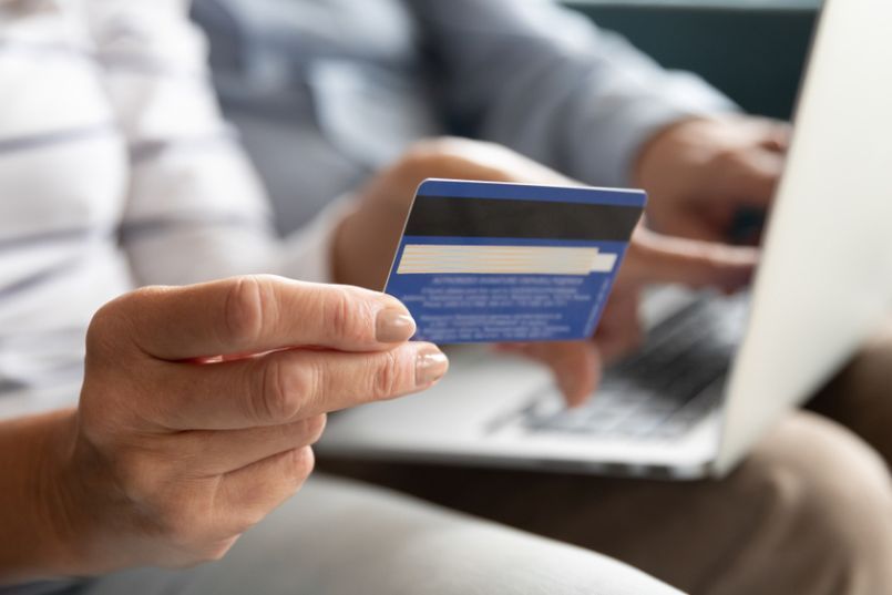a woman holding a credit card illustrating line of credit vs. loan