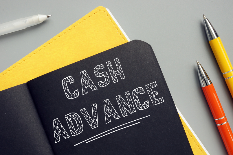  a notebook with the words cash advance written on it laying on a table