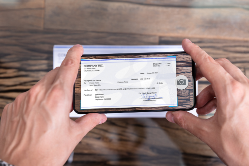 a man taking a picture of a check for a mobile deposit without an ID