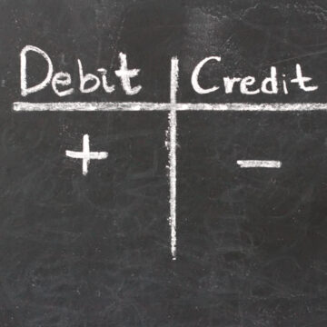 Word debit and credit in a grid on a chalkboard