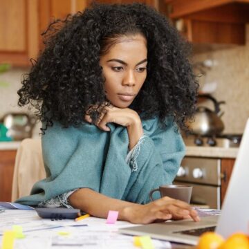 Woman on a laptop with documents over a table