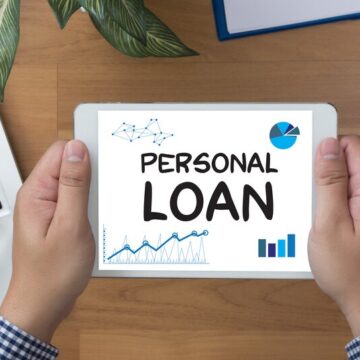 Man holding a tablet with the words personal loan displayed