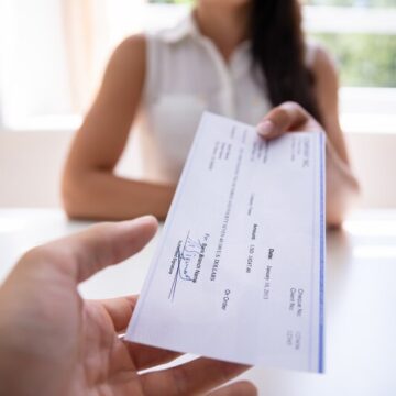 Businesswoman giving a check to a colleague