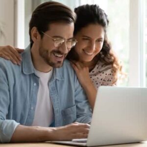 Couple researching loan options online together.