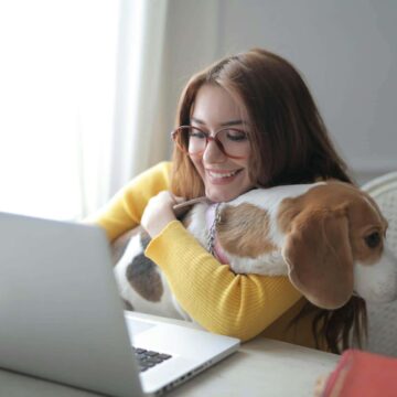 Woman with dog using computer for personal finances.