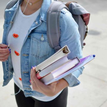 College student holding text books.